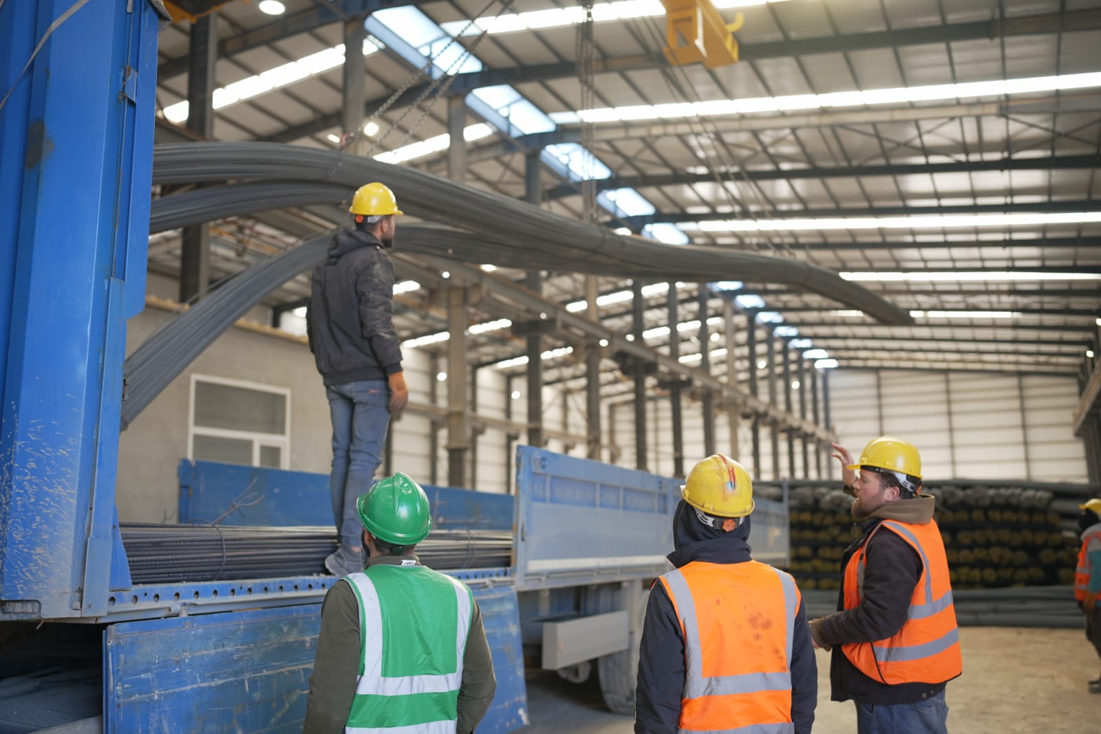 Workers loading rebar bundles onto a delivery truck at Sabaeek