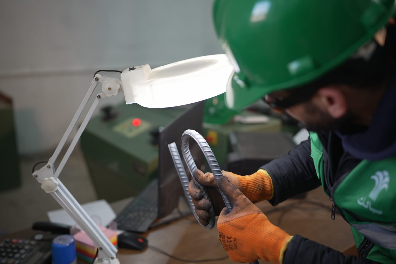 Technician examining a rebar sample in the Sabaeek laboratory